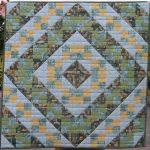 Muted green and apricot quilt