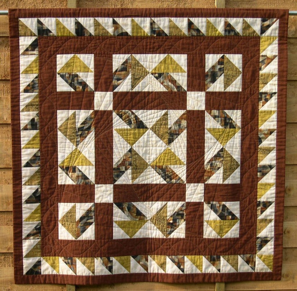 Brown aand ye;llow patchwork quilt in Jack-in-a-Box design