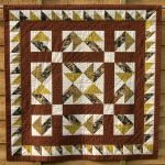 Brown aand ye;llow patchwork quilt in Jack-in-a-Box design