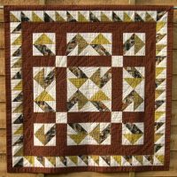 Brown aand ye;llow patchwork quilt in Jack-in-a-Box design