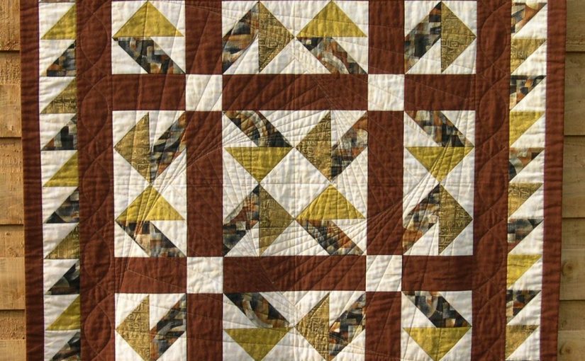 Brown aand ye;llow patchwork quilt in Jack-in-a-Box design