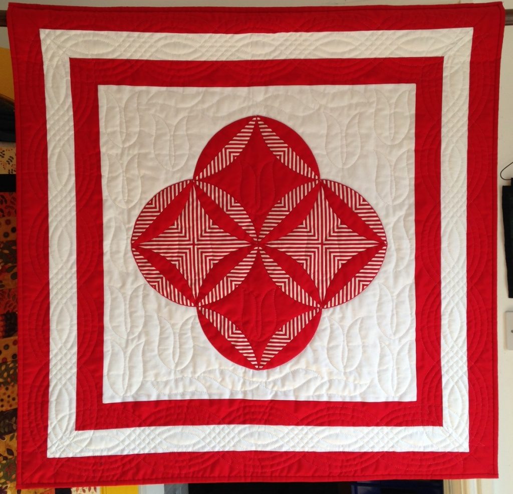 Red and white quilt with striped fabric