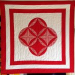 Red and white quilt with striped fabric