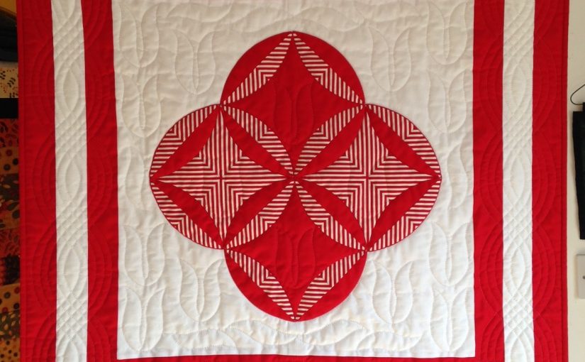 Red and white quilt with striped fabric