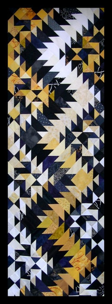 Yellow, black and white patchwork arranged in long zigzag.