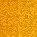 Bright yellow quilt with paisey border