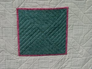 Green pocket stitched onto the quilt back