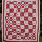 Red and white quilt with circular motifs