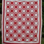 Red and white quilt with circular motifs