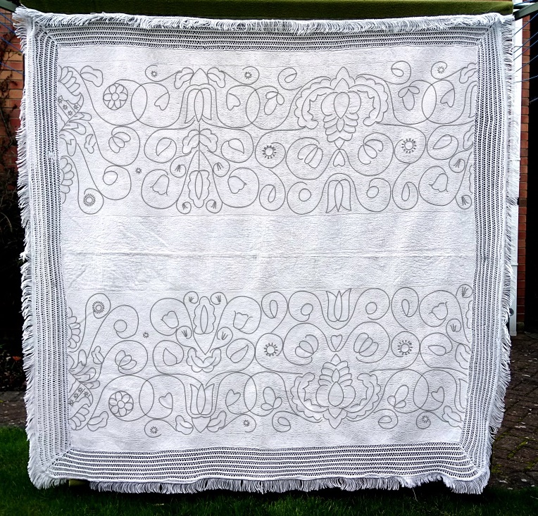 Black lines of pattern are drawn over the white-on-white quilt