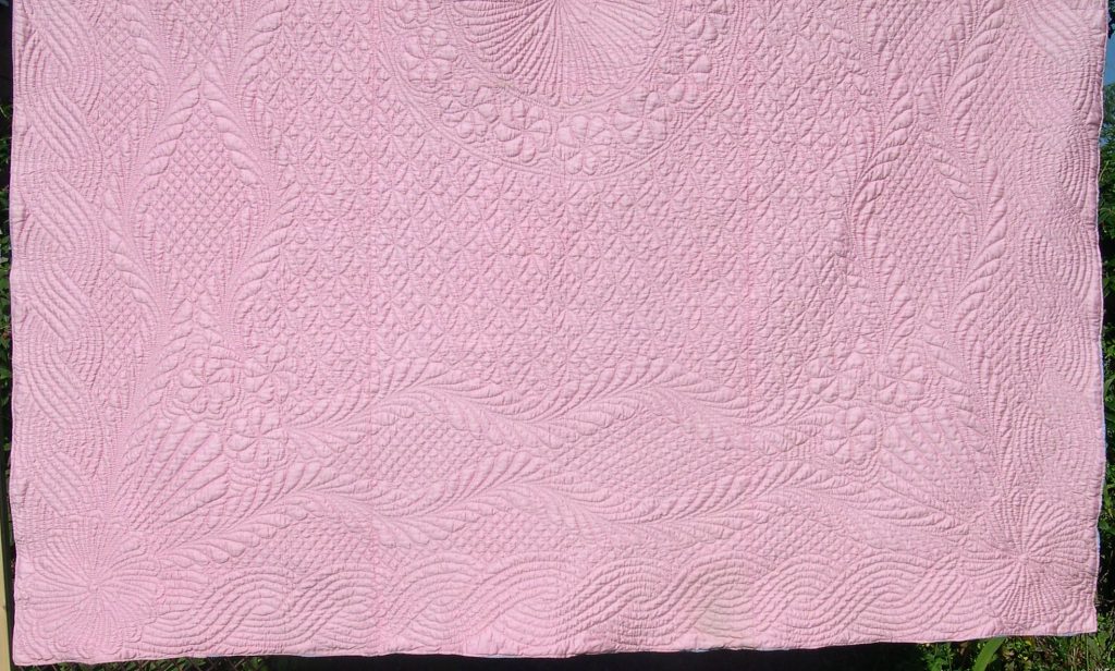 Pale pink quilt with feather bellows quilting design