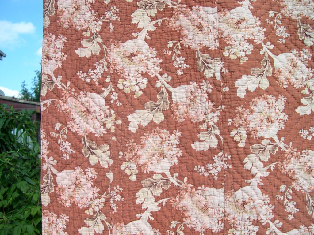 Narrow strip of floral fabric stitched onto the edge of the quilt back