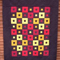 A simple but striking lap quilt in red, yellow and black