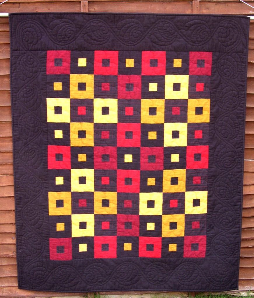 A simple but striking lap quilt in red, yellow and black