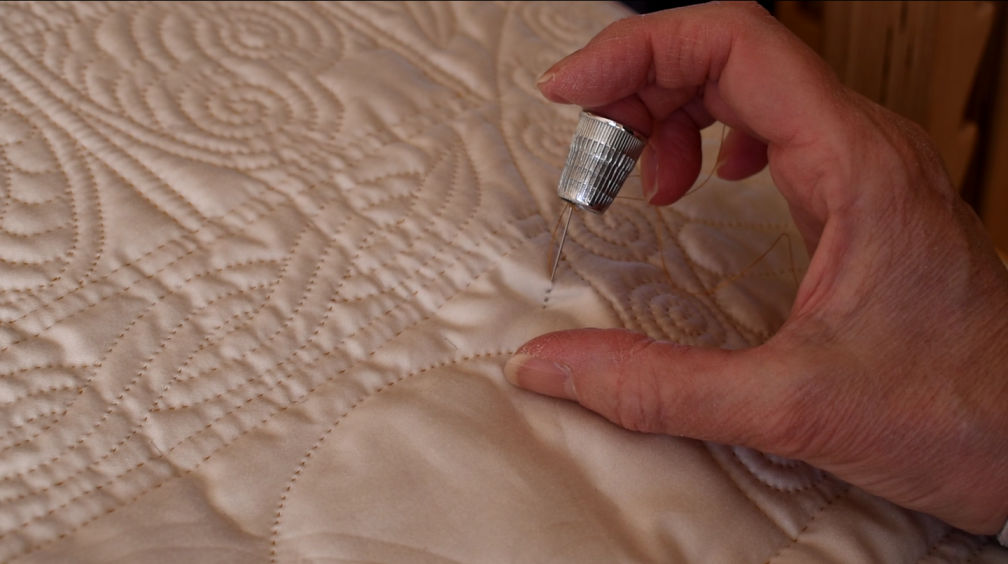 Wholecloth quilt being stitched by hand