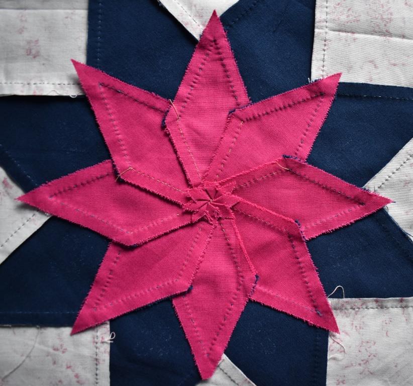 Pink star pieces with seam allowance maniplulated into a spiral