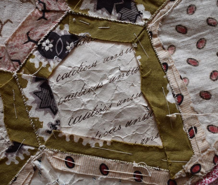 The hand-written phrase "cautious answer" is repeated several times on the paper used in this quilt top.