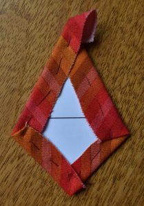 Red stripy fabric tacked over kite-shaped card