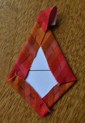 Red stripy fabric tacked over kite-shaped card