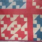 Four red and cream patchwork blocks arranged next to each other