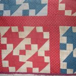 Four red and cream patchwork blocks arranged next to each other