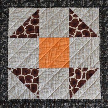 Brown and orange simple patchwork block with diagonal quilted grid.