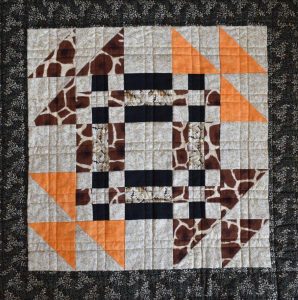 Brown and orange patchwork block with quilted double lined grid