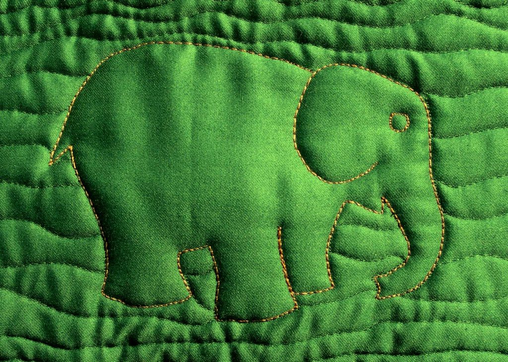 Quilted elephant design on green background