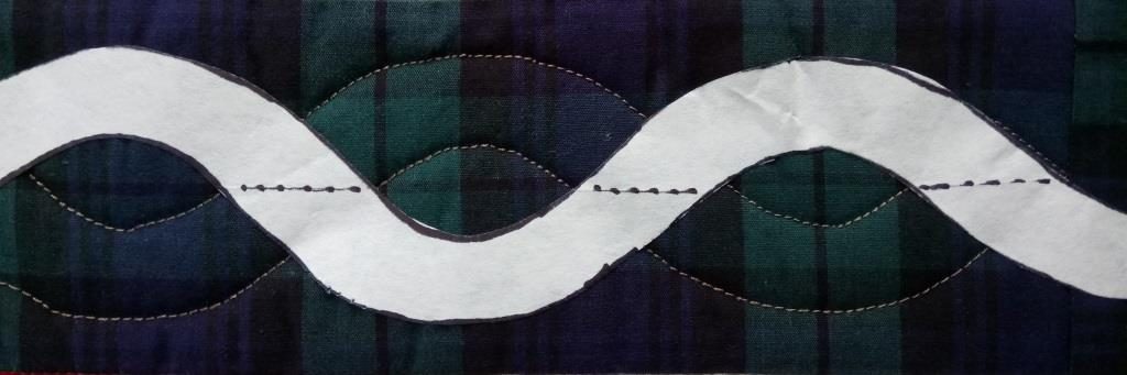 Paper waving line forming one strand of a quilted cable design