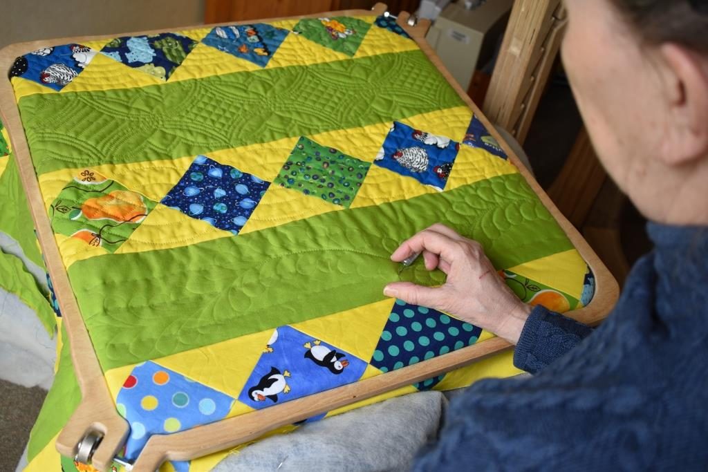 Carolyn Gibbs hand quilting using floor-standing hoop.