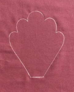 White outline of cowslip leaf on purple fabric