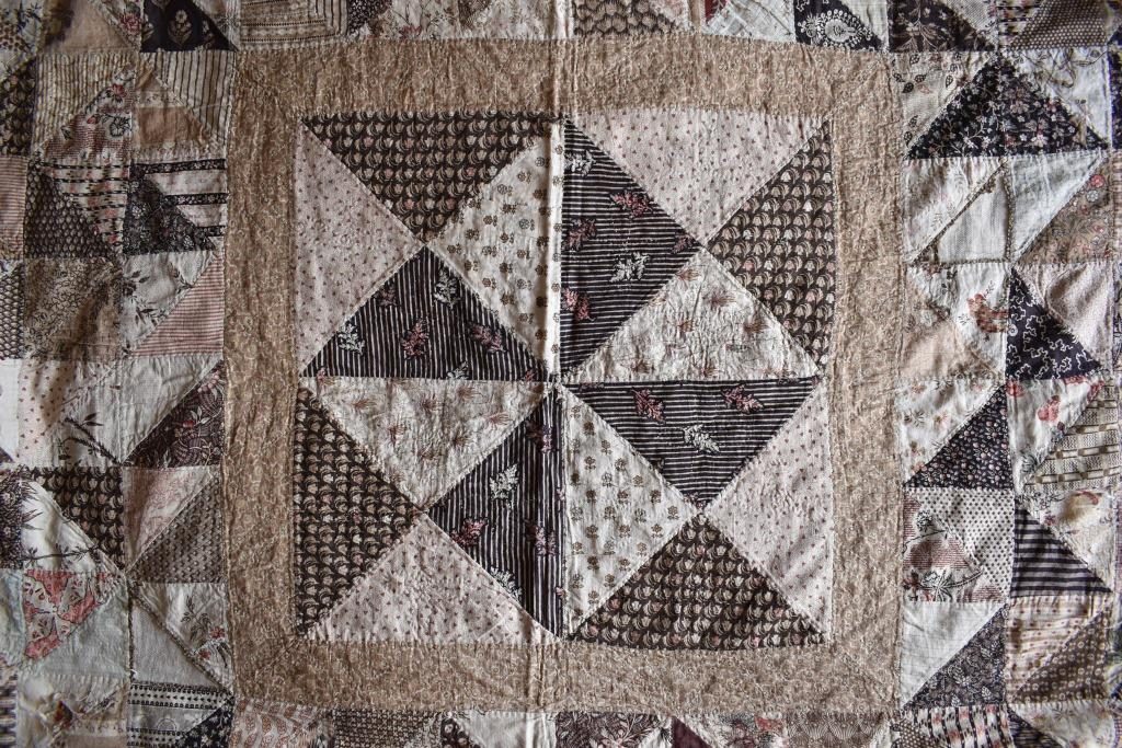 Four quarter-square triangle units of patchwork in brown and cream