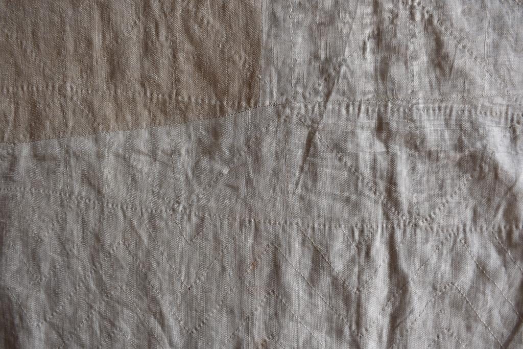 Cream linen backing with visible quilting pattern