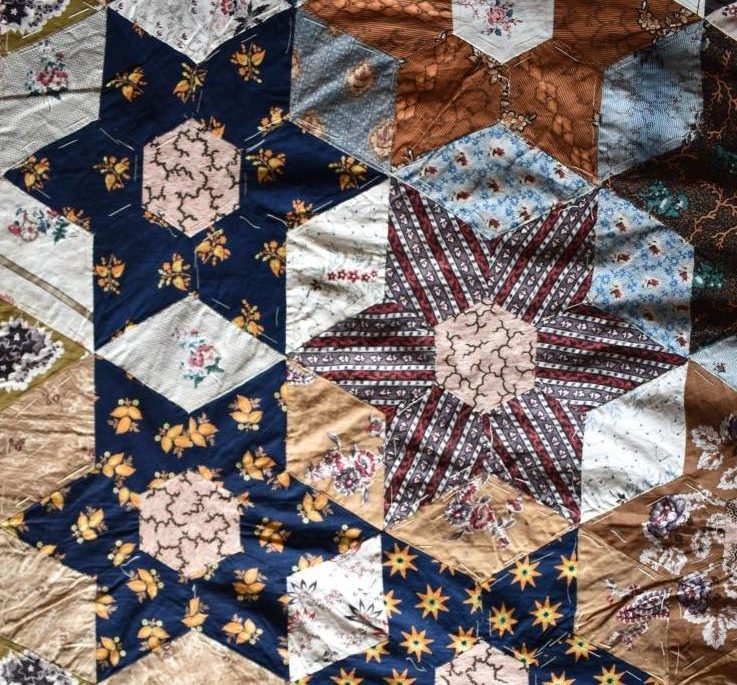 Coloured patchwork stars in quilt top.