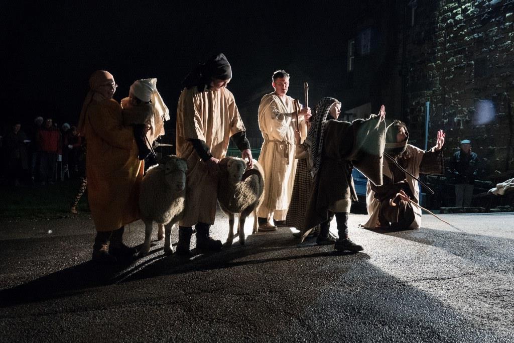 People dressed as shepherds, in semi-darkness