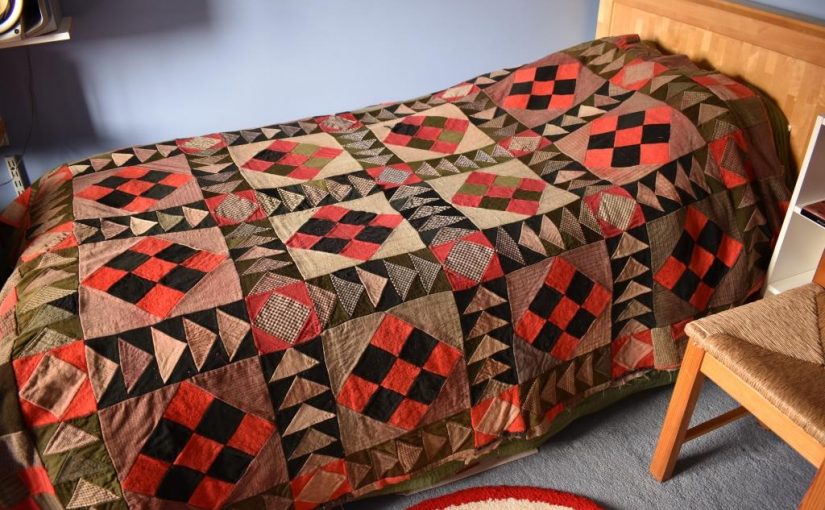 Patchwork squares and triangles in red, black green and grey