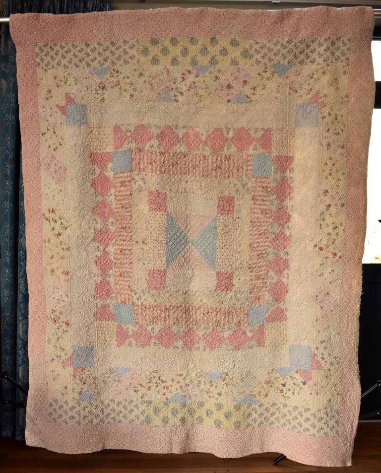 Patchwork quilt with multiple borders in pinks and blues