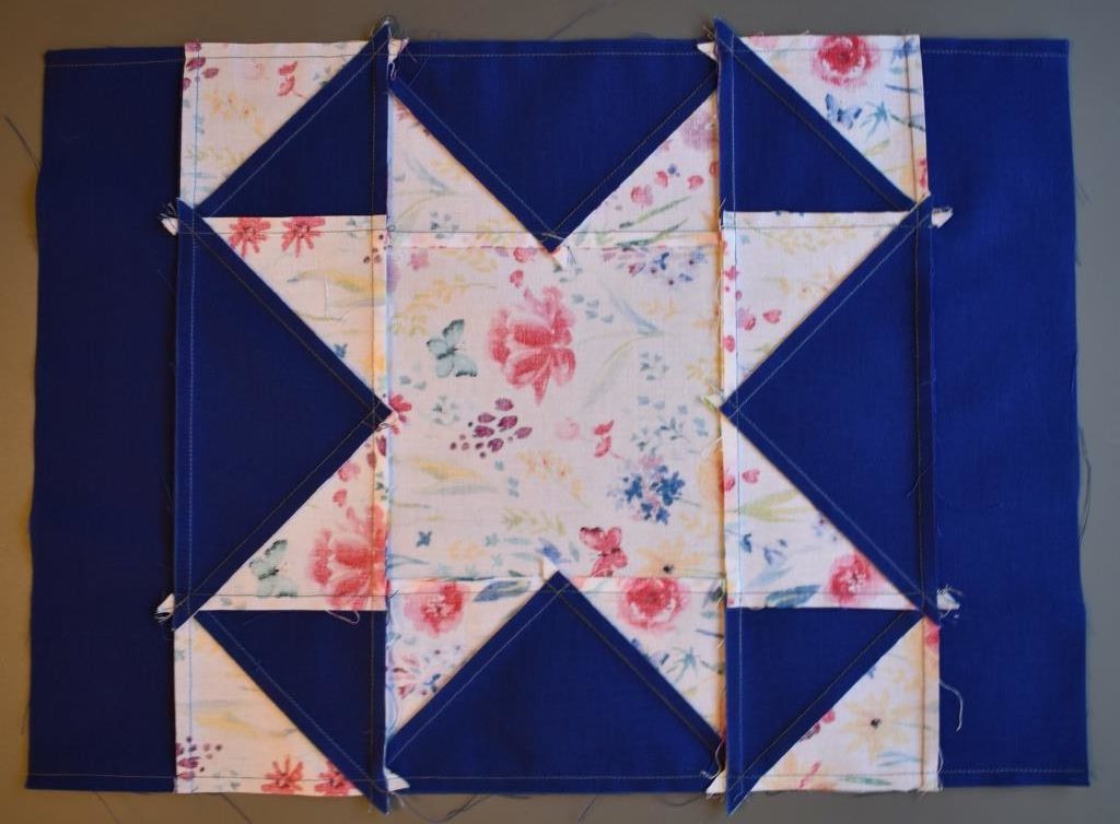 Blue border on patchwork star with seams pressed towards border