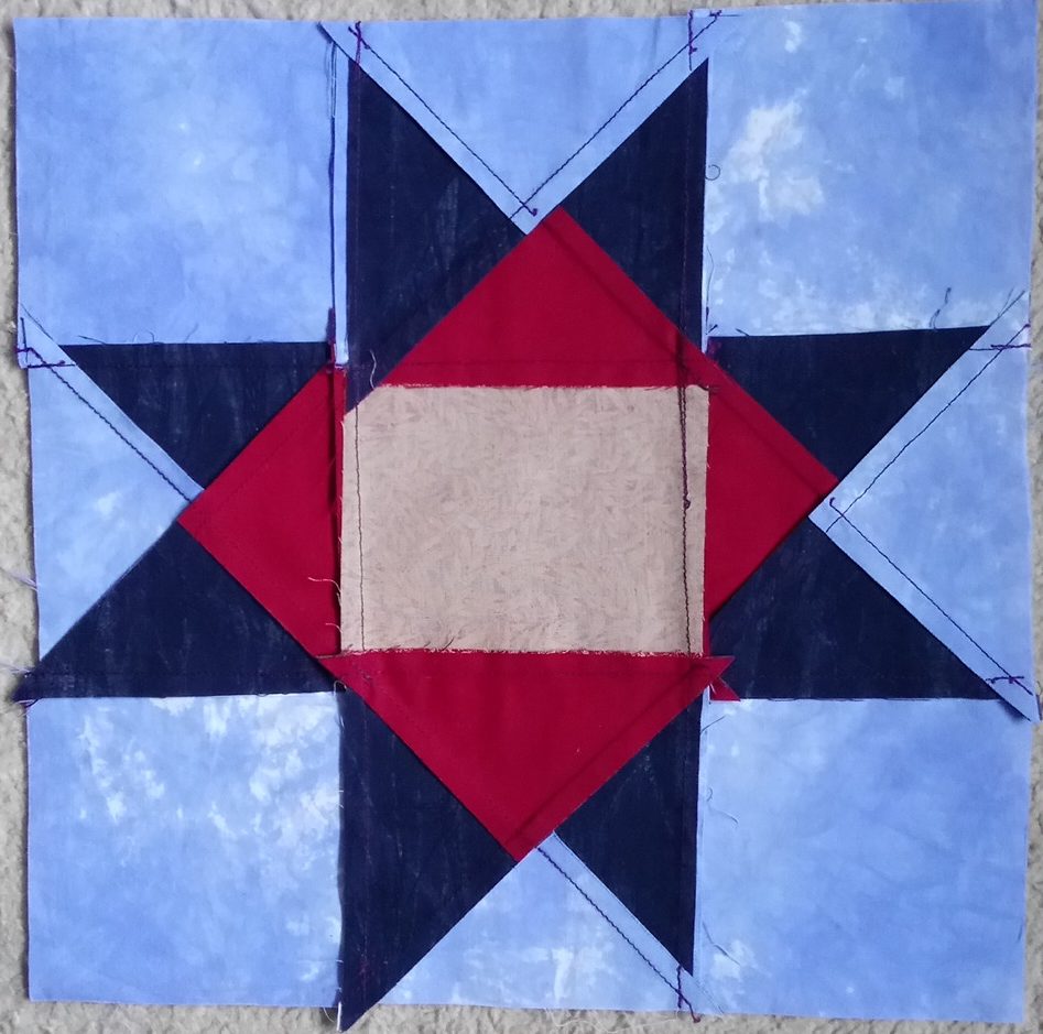 Back of patchwork block showing some seams pressed behind lighter fabric