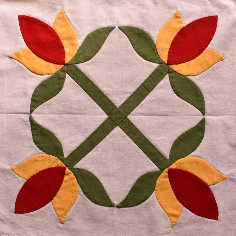 Stylized four-fold symmetrical design of red & yellow tulips with green leaves