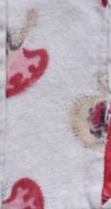 Close-up of printed fabric showing randomised dots around printed motif