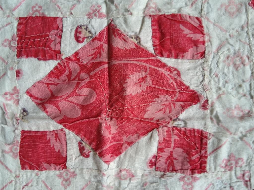 Close-up of patchwork section showing dark red on pale red printed design